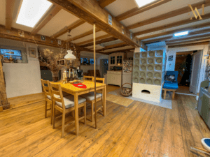 Wohn-und Essbereich mit Kamin und sichtbarem Holzgebälk