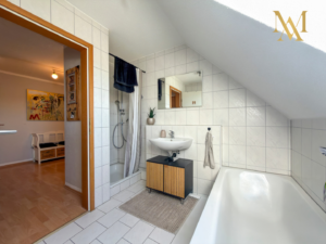 Das Badezimmer mit Fenster, Wanne und Dusche